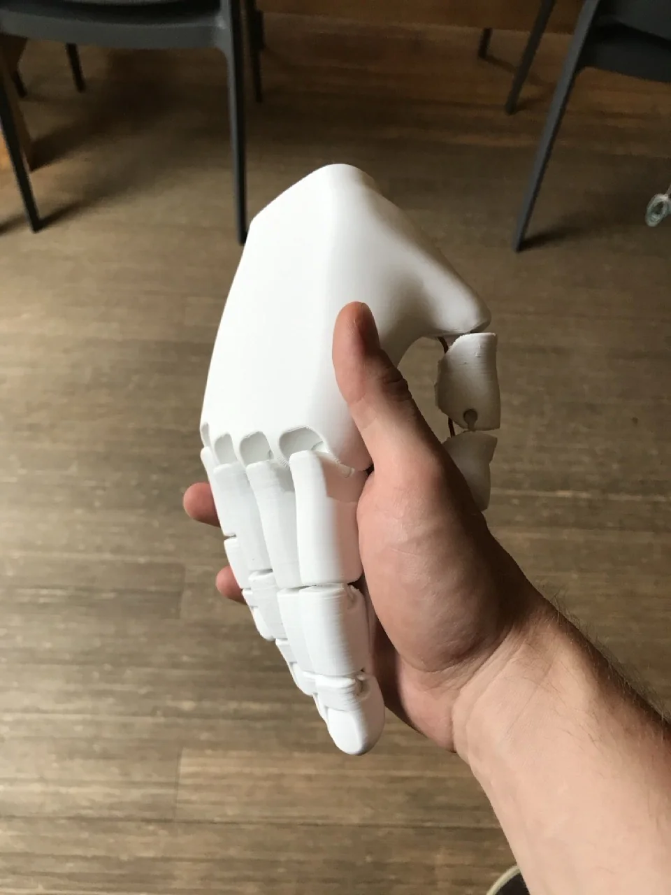 Main articulée imprimée en 3D tenue dans une main