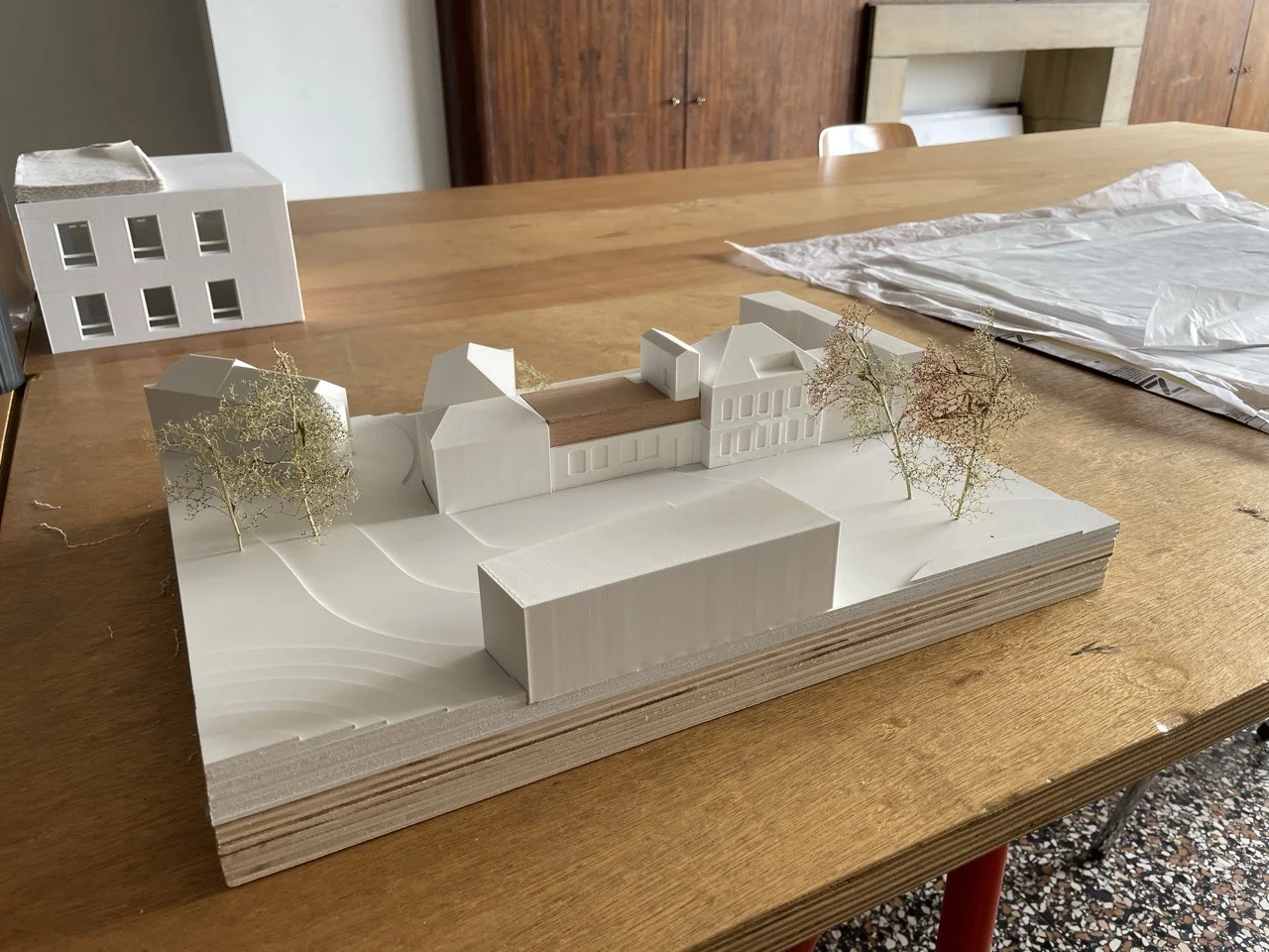 Maquette architecturale blanche d’un ensemble de bâtiments sur socle en bois